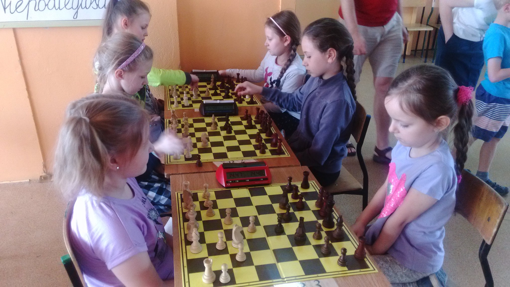 Dziewczynki grające w szachy przy kilku stolikach w sali, MUKS Gambit Międzyrzec Podlaski