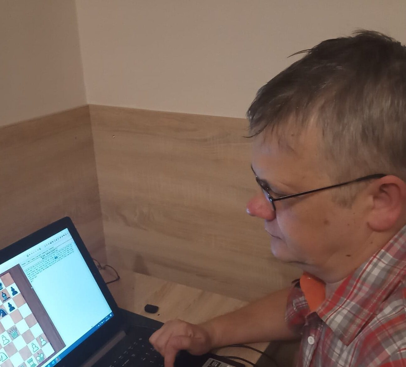 Mężczyzna analizuje partię szachów na laptopie, trener szachów Mirosław Perdek z Wrocławia