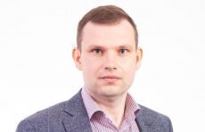 Mężczyzna w marynarce i krawacie pozuje do zdjęcia portretowego, trener szachów Marcin Pieczonka z Warszawy