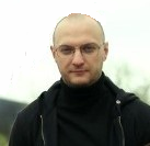 Mężczyzna w czarnej bluzie pozuje na zewnątrz, trener szachów Rafał Roszkowski z Białegostoku