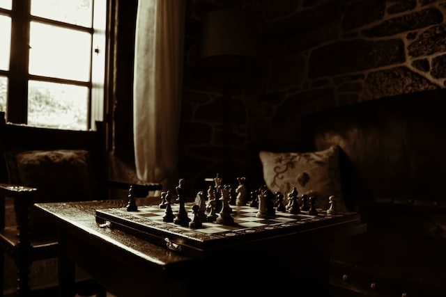 Plansza szachowa położona na stoliku przy oknie